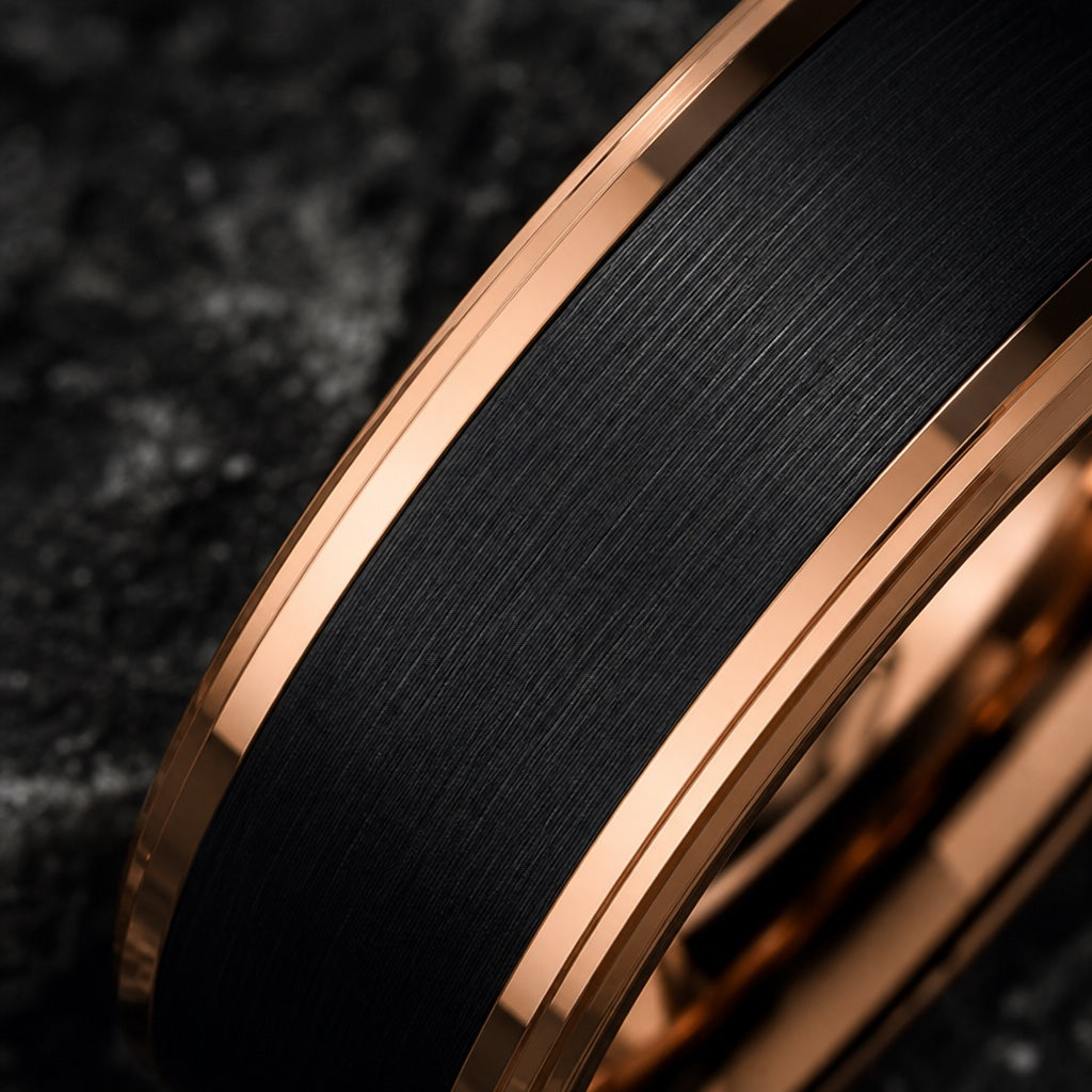 Macro of the Boss ring's brushed black charcoal tungsten centre between rose-gold rails on dark charcoal stone