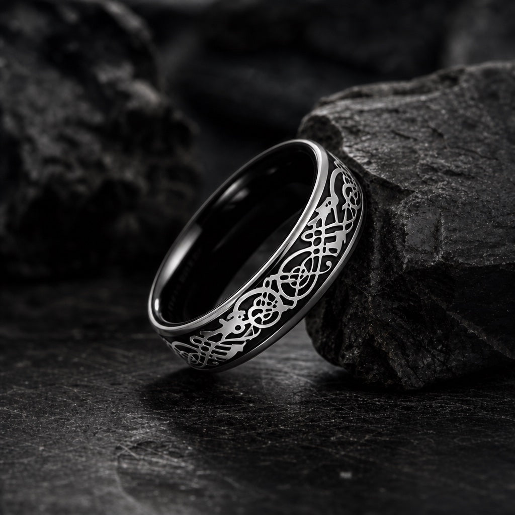 The Drago ring resting against dark rock, black body and raised silver dragon relief visible