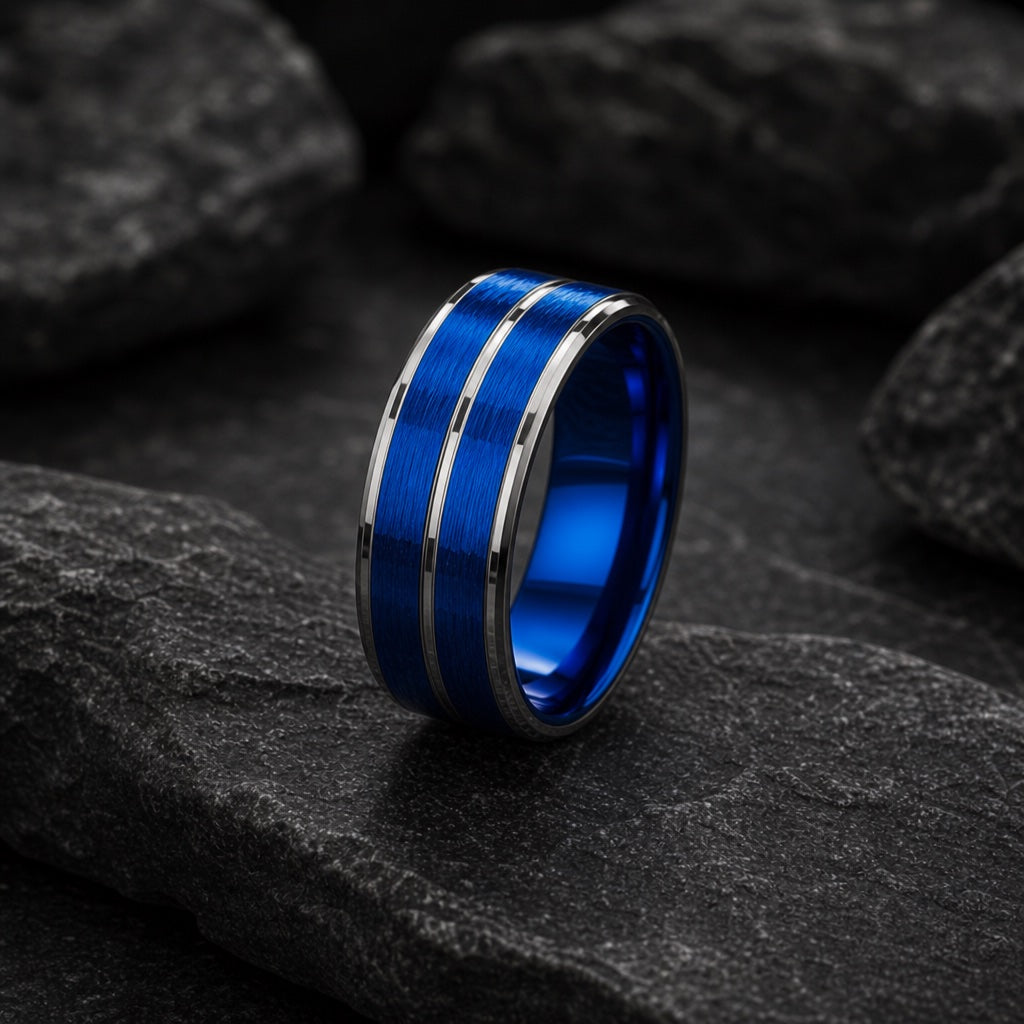 The Dynamo ring resting against dark rock, electric-blue face and twin silver rails visible