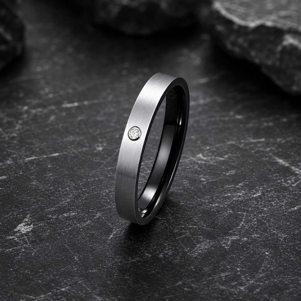 Ice ring showing flat pipe-cut brushed silver profile and flush clear stone against dark stone