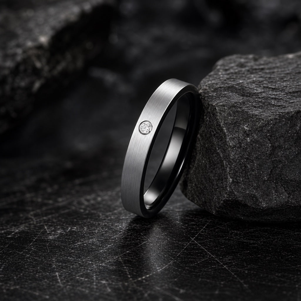 The Ice ring resting against dark rock, slim brushed silver body and flush clear stone visible