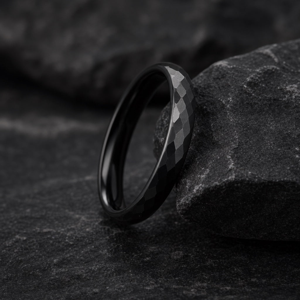Marvel ring angled to show the slim 4mm round domed outer edge and hammered matte black face on dark stone