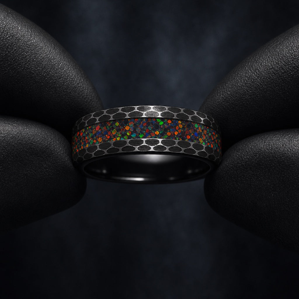 Black latex gloves presenting the Prime ring with centred opal fire and hammered black flanks