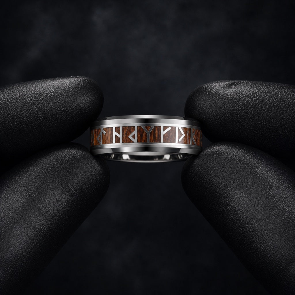 Gloved hands presenting the Raider ring, wood inlay runes and comfort-fit curve visible
