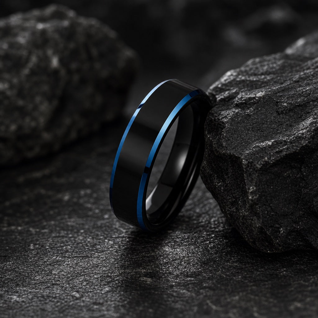 The Shock ring leaning on dark charcoal rock, polished black face and electric blue bevels visible