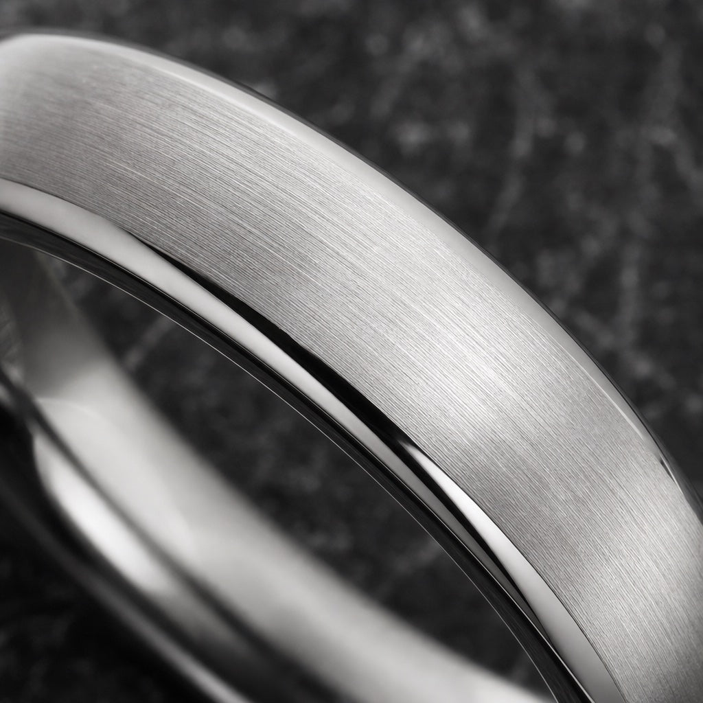 Macro of the Wisp ring's brushed satin silver dome on dark charcoal stone