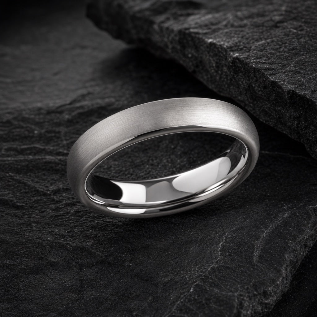 Wisp ring angled on dark charcoal stone to show the polished blank silver interior