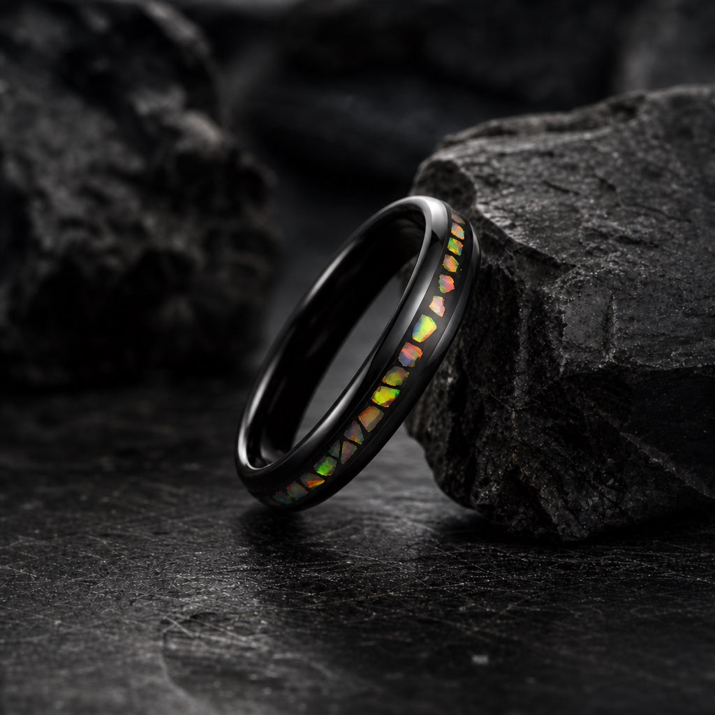 The Angel ring resting against dark rock, polished black body and crushed fire inlay visible