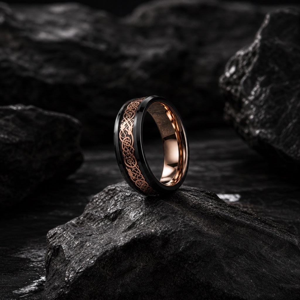 The Basilisk ring resting against dark rock, black body and rose-gold filigree visible