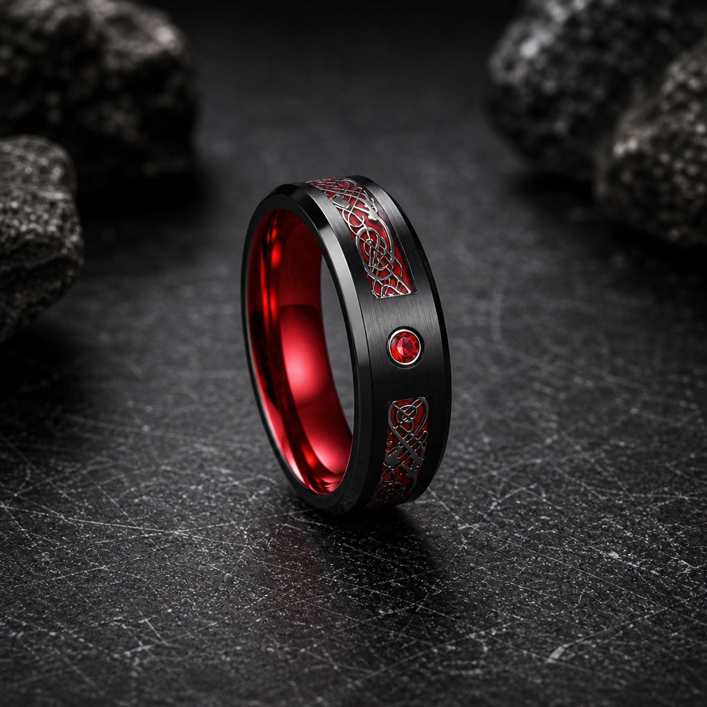 Cardinal ring showing brushed black face, red Celtic channel, flush red centre stone, and polished black bevelled rims