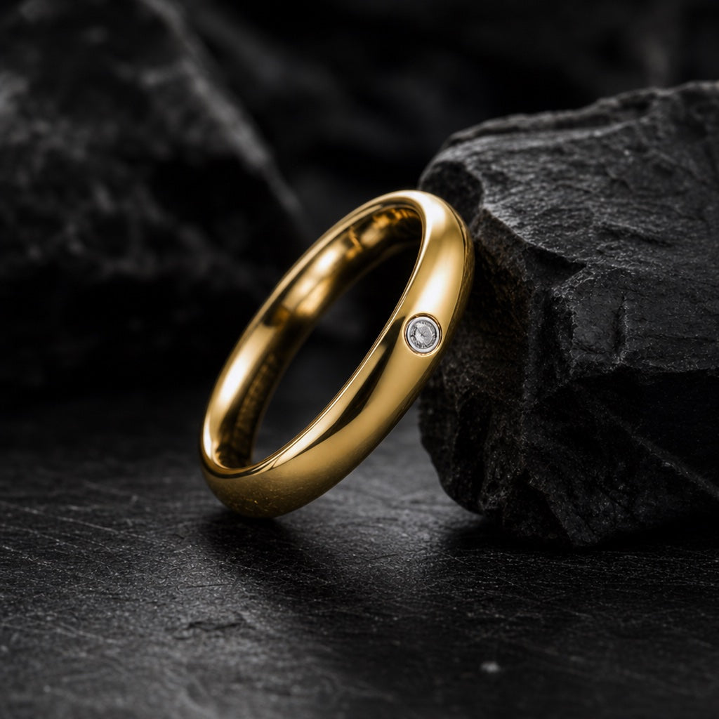 The Halo ring resting against dark rock, polished gold body and clear CZ visible