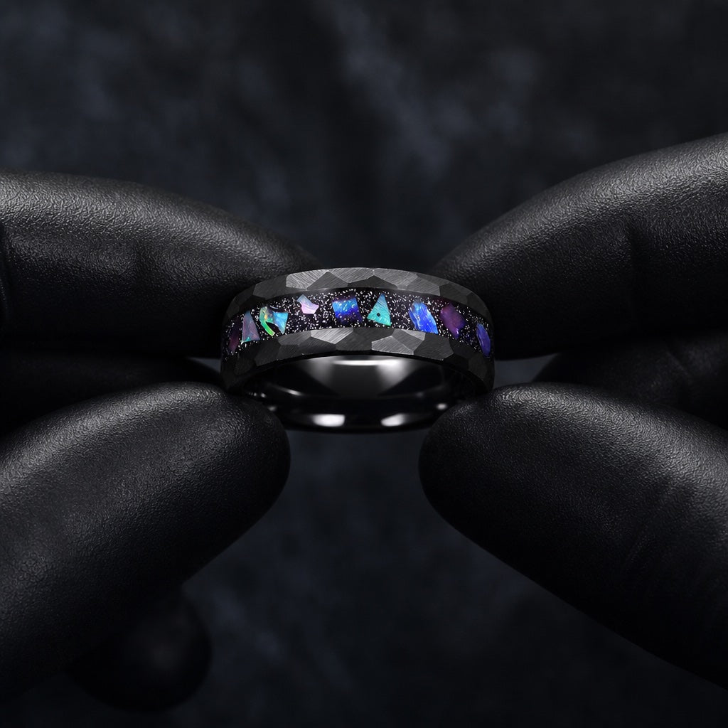 Black latex gloves presenting the Magus ring with hammered black rails and centred galaxy abalone