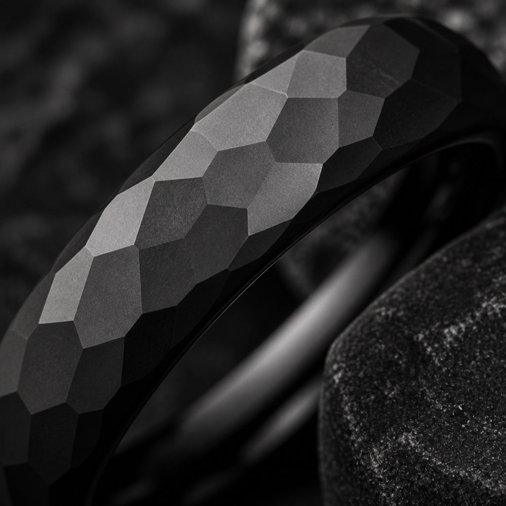 Extreme close-up of the Marvel ring's hammered matte black facets on dark charcoal stone