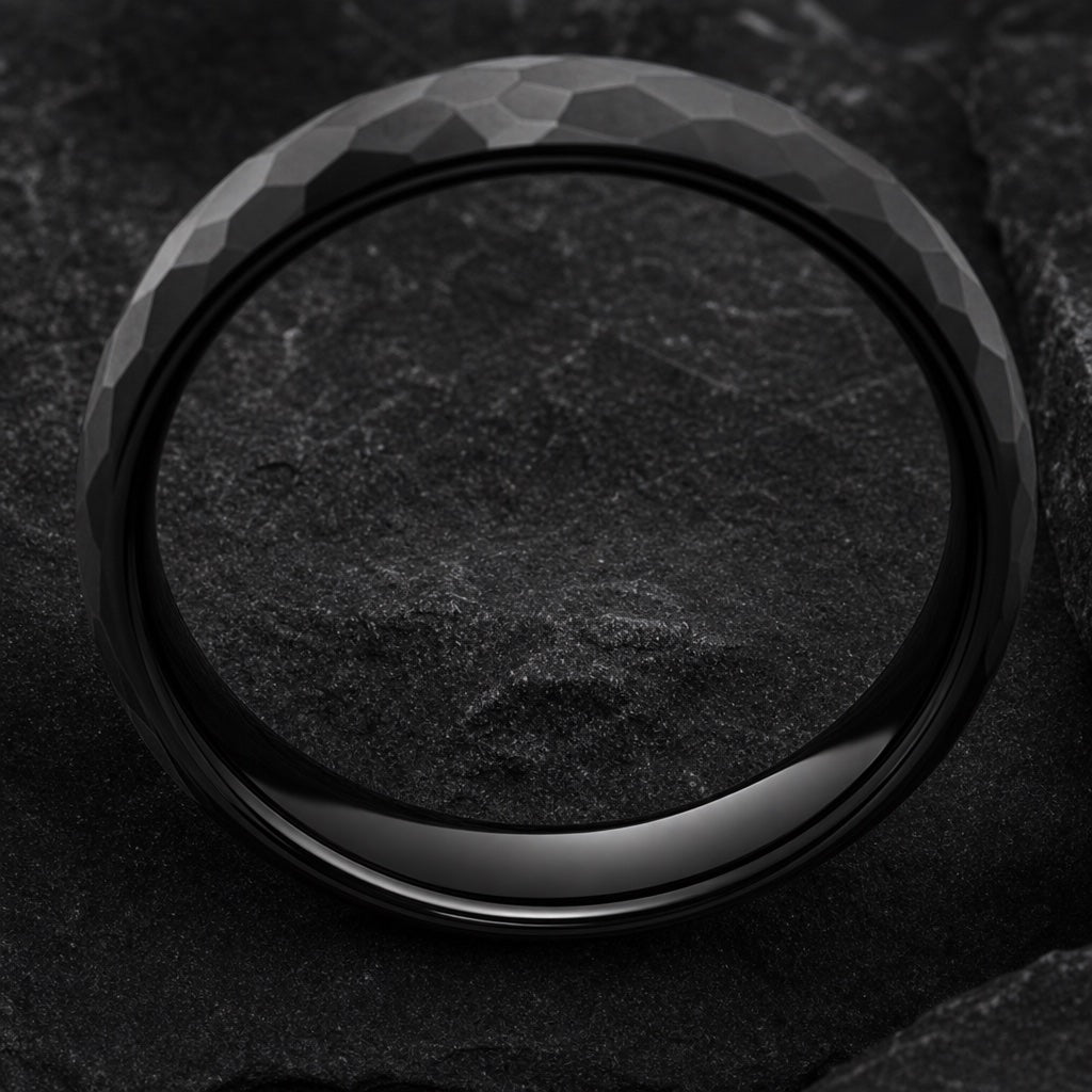 Marvel ring angled on dark charcoal stone so the polished black blank interior fills most of the frame