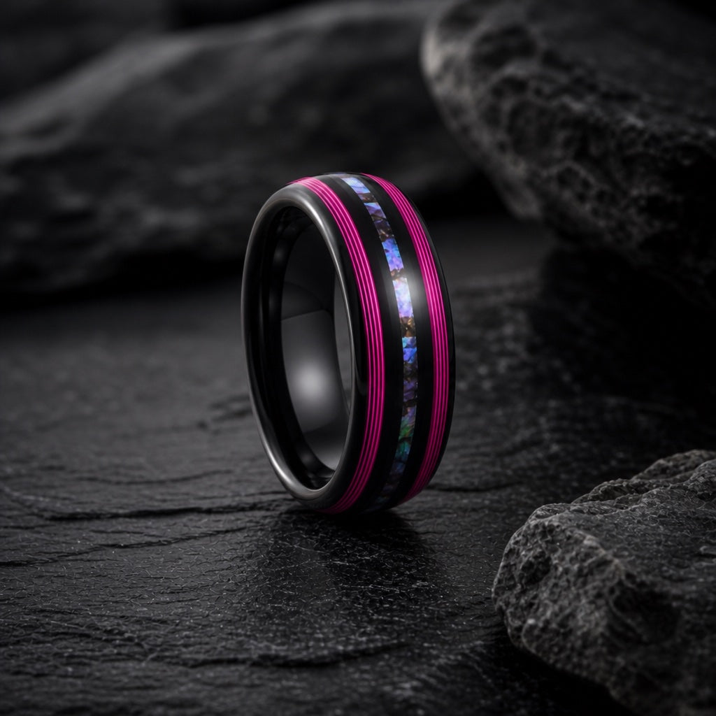 Neon ring showing vivid neon pink magenta flanking rails beside the centred abalone on dark charcoal stone