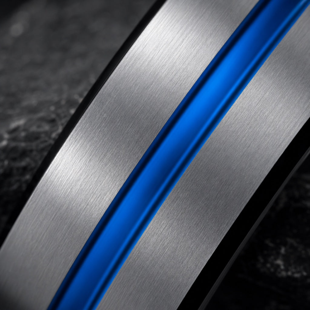 Macro of the Sublime ring's thin centred electric-blue groove on brushed silver against dark charcoal stone
