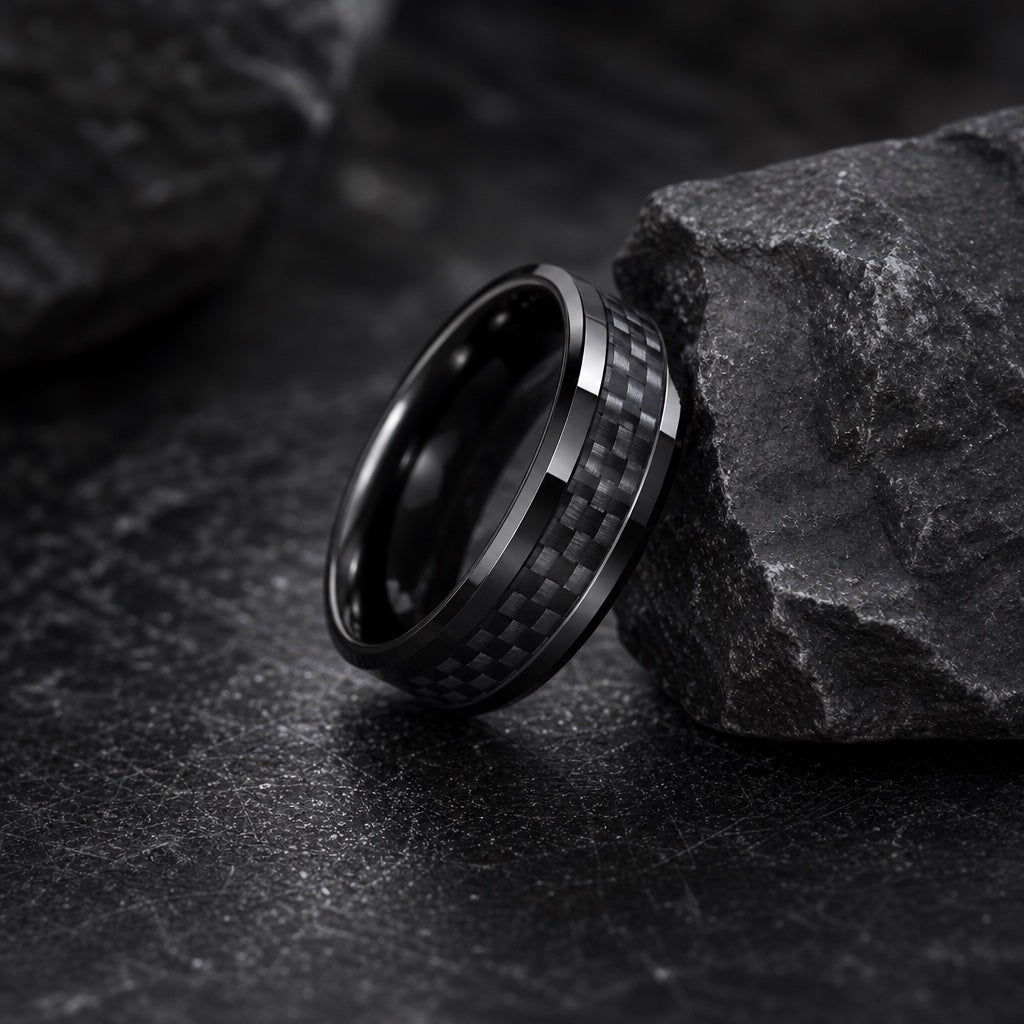 The Turbo ring resting against dark charcoal rock, polished black body, centred carbon-fibre weave and black interior visible