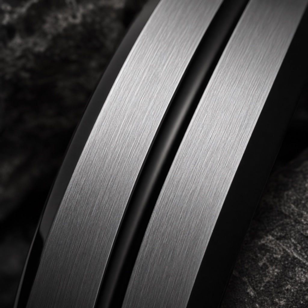 Macro of the Viceroy ring's thin centred black groove on brushed silver tungsten against dark charcoal stone