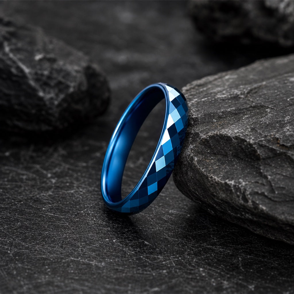 The Virtue ring resting against dark rock, faceted electric-blue body visible