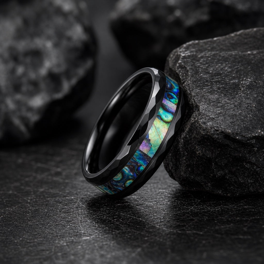 Warlock ring full band on dark charcoal rock with faceted black rails and centred abalone visible